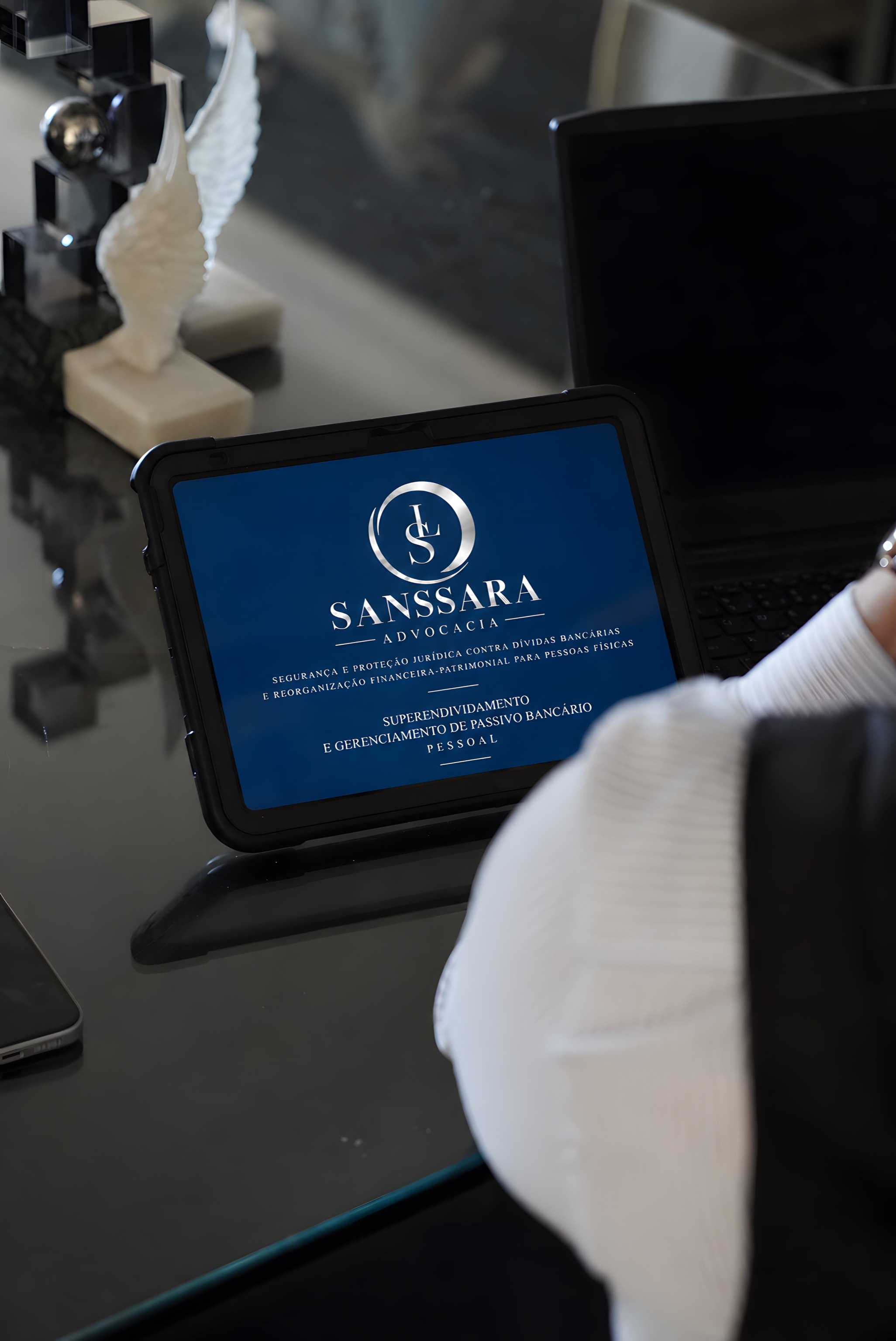 Tablet com o logotipo da Sanssara Advocacia sobre a mesa do escritório